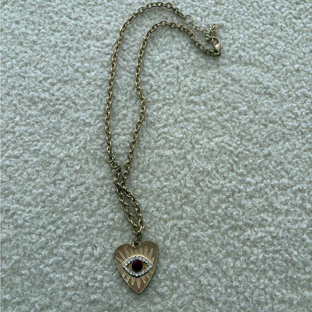 Vintage gold heart shaped necklace with evil eye detail and red stone in center